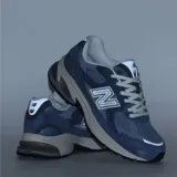 Championes urbanos New Balance modelo 2010, color azul con detalles en gris y blanco. Presentan una combinación de malla y gamuza en el exterior, con el logo N característico en los laterales y una entresuela robusta con tecnología de amortiguación.