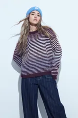 Sweater de tejido de punto con diseño de rayas horizontales en tonos bordó y celeste. Presenta cuello redondo, corte holgado y mangas largas con puños ajustados.