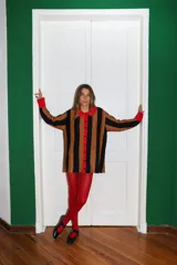 Saco tejido a máquina con rayas verticales negras y marrones, cuello camisero y botones rojos.