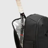 Mochila deportiva negra de diseño minimalista, con múltiples compartimentos, incluyendo espacio térmico para raquetas, bolsillo inferior ventilado para calzado y compartimento interno para laptop.