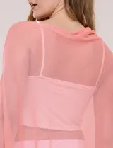 Poncho liviano de tejido de punto fino calado, color blanco, con silueta asimétrica envolvente, escote bote drapeado y mangas integradas estilo capa.