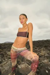 Pantalón de tul con estampado abstracto en tonos tierra, rojo y verde. Tiene elástico en la cintura y corte acampanado.