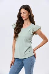 Remera de algodón color beige, de manga corta con volados de broderie, escote redondo y cuerpo liso.