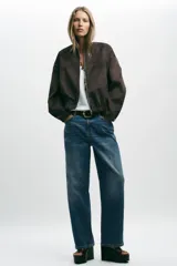 Campera bomber color beige, de cuello redondo y manga larga. Tiene bolsillos delanteros y bajo acabado en elástico. Cierre frontal con cremallera.