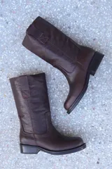 Bota de cuero marrón con caña media, puntera redondeada y detalle de costuras.