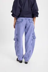 Jean de corte baggy con pierna recta y ancha, color verde oscuro con efecto lavado. Presenta bolsillos cargo laterales, costuras reforzadas y detalle de bordado del isologo en la parte trasera.