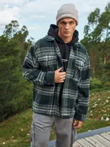 Sobrecamisa a cuadros verde oscuro, marrón y blanco, de manga larga con puños abotonados, cierre frontal con botones y bolsillos en el pecho.