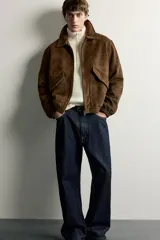 Cazadora de hombre regular fit confeccionada en tejido efecto ante, con acabado lavado, cuello solapa, manga larga, bolsillos de plastrón con solapa en la cadera, detalles elásticos en puños y cintura, y cierre frontal de cremallera.