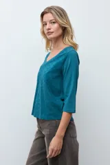Remera de manga tres cuartos con escote en V, confeccionada en tela con textura de broderie en el frente.