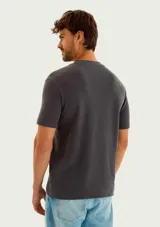 Remera gris de manga corta con textura tipo waffle y pequeño bordado en el pecho.