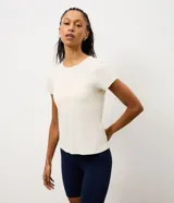 Remera deportiva de manga corta y cuello redondo, confeccionada en tejido crepe de poliamida. Presenta un diseño liso en color blanco con estampa frontal con la palabra 'Practice' en efecto gel.