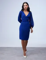 Vestido azul de RM Richards en seda fría, con escote en V cruzado, cintura drapeada, mangas largas de gasa y aplique de botones en el lateral.