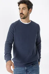Sweater de punto en color azul marino, con cuello redondo y mangas raglán. Presenta un tejido acanalado fino y puños elásticos.