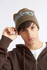 Gorro reversible de invierno Quiksilver, color marrón con diseño estampado y detalles en celeste.