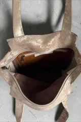 Cartera de cuero de la marca Carolina De Cunto, modelo Nia de la línea Ottenta Basic. Presenta diseño combinado en tonos marrón y tostado con detalles en pelo natural con estampado animal print, bolsillos con cierre exterior e interior, porta llaves y doble asa de hombro.