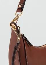 Cartera de hombro de diseño ovalado en color marrón, con cierre de cremallera y herrajes metálicos dorados.