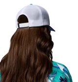 Gorra Columbia x Disney tipo trucker, con panel frontal de color verde, visera fucsia, paneles traseros de malla blanca y parche redondo con gráfico de Mickey Mouse practicando esquí. Incluye etiqueta lateral con el logo de Columbia y Disney.