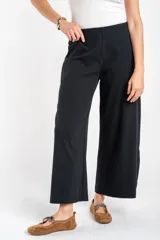 Pantalón negro de corte ancho y relajado, confeccionado en algodón texturizado.