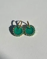 Aros colgantes dorados con dije circular de resina color turquesa, bordeado con strass. El arito es de acero quirúrgico.