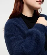 Cardigan abierto de punto pesado con textura peludita, manga larga y diseño alargado. Prenda versátil de corte holgado.