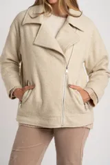 Campera de abrigo color crema, con cuello solapa y cierre asimétrico frontal. Presenta textura bouclé o de lana rizada.