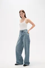 Pantalon de jean azul de corte ancho y tiro medio, con diseño de cinco bolsillos y cierre frontal con botón y cremallera.
