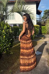 Vestido largo strapless de fibrana con estampa tie-dye en tonos marrones y beige, con espalda baja descubierta y diseño entallado al cuerpo.