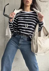 Remera negra con rayas horizontales blancas, de corte recto y mangas largas.