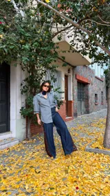 Camisa de corte oversize con estampado de cuadros en tonos grises. Presenta cuello camisero, mangas largas abullonadas y cierre frontal con botones.