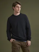 Sweater de cuello redondo confeccionado en algodón, con diseño de tejido liso y puños y ruedo acanalados.