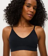 Soutien tipo top de diseño seamless, confeccionado en poliamida texturizada de color negro. Presenta base ancha, copas removibles y breteles finos regulables.