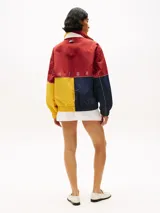 Campera de nailon con diseño color block en rojo, amarillo y azul marino. Tiene cuello alto, cierre de cremallera oculto con botones a presión, puños y bajo elásticos, dos bolsillos ribeteados en la cintura y logo de Tommy Hilfiger en la parte delantera, la trasera y las mangas.