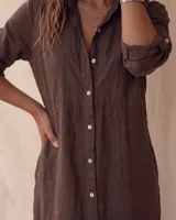 Vestido camisero midi blanco de lino, con cuello camisero, botonadura frontal completa con botones de nácar, mangas largas con tira para arremangar y abertura lateral en el bajo.
