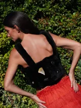 Top negro de corderito natural con breteles y broches en la espalda. Decorado con pins variados.