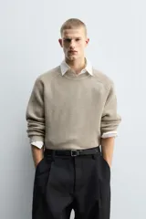 Jersey de punto con diseño boxy fit, cuello redondo y manga larga. Presenta una textura acanalada y acabados en rib en puños y ruedo.