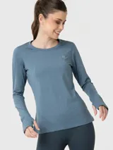 Polera deportiva de manga larga con cuello redondo, confeccionada en tejido técnico de efecto jaspeado. Presenta aberturas para los pulgares en los puños y un pequeño logo bordado en el pecho.