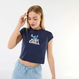 Camiseta azul marino crop top con manga corta y cuello redondo. Cuenta con un estampado frontal de Stitch y el texto "Just Chill" en color blanco.