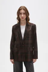 Blazer de corte holgado con diseño a cuadros en tonos marrones y negros. Presenta cuello con solapa, cierre frontal con un botón y bolsillos laterales con solapa.