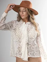 Camisa de encaje color crema, con corte clásico, volado frontal y botones al frente.