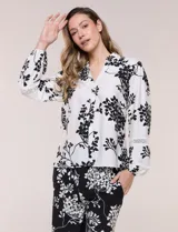 Conjunto de camisa y pantalón amplio con caída fluida. Camisa con escote en V y abotonadura frontal, mangas largas de corte caído con detalle de puntilla calada y puños elastizados fruncidos. Pantalón de tiro alto con cintura elastizada, pierna holgada de corte wide leg con dobladillo ancho en el ruedo y bolsillos laterales.