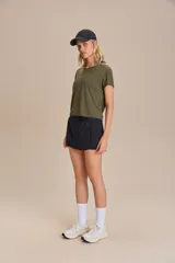 Remera deportiva verde militar de calce suelto, con mangas cortas, sisas desplazadas y abertura en la espalda. Confeccionada en tejido liviano y respirable con tecnología Quick Dry y Easy Care.