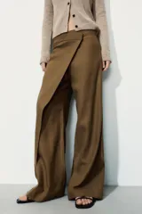 Pantalón de tiro medio confeccionado en mezcla de lino, con diseño de pierna recta y detalle de superposición frontal tipo pareo. Cuenta con cierre frontal mediante cremallera, botón y gancho metálico.