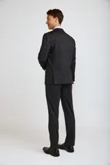 Ambo de corte slim compuesto por saco de dos botones y pantalón de vestir a juego, en color azul marino. El saco presenta solapas clásicas, bolsillos laterales con solapa y bolsillo en el pecho con pañuelo decorativo.