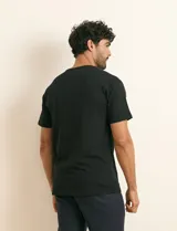 Remera básica de algodón color beige, de manga corta, con cuello redondo y un pequeño detalle bordado en el pecho.