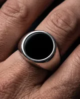 Anillo tipo sello de acero con piedra central redonda color negro.