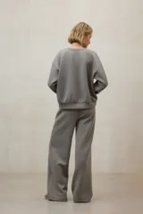 Buzo de cuello redondo, manga larga con puños elásticos y ruedo con banda elástica. Presenta un diseño minimalista y holgado.