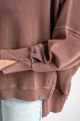 Sweater de algodón peinado con efecto lavado, de corte oversize, cuello redondo y mangas largas con costuras visibles.
