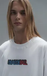 Remera blanca de corte oversize con cuello redondo y mangas cortas. Presenta un estampado central en la espalda con los personajes Goku y Goten de Dragon Ball.