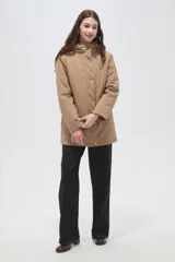 Campera 3 en 1 color beige, compuesta por una campera exterior impermeable con capucha y una campera interior capitonada con cierre frontal y cuello alto.