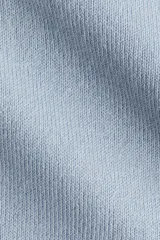 Sweater de punto fino color celeste claro, con cuello polo y tapeta de botones. Presenta hombros ligeramente caídos y remates acanalados en puños y bajo.
